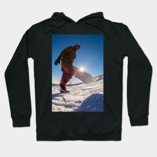 Snowboarder walking against blue sky Hoodie